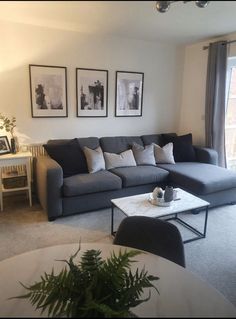 a living room filled with furniture and pictures on the wall