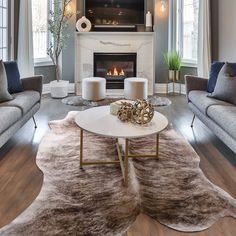 a living room filled with furniture and a flat screen tv mounted on the wall above a fire place