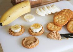 an assortment of cookies, crackers and bananas on a cutting board next to a banana peel