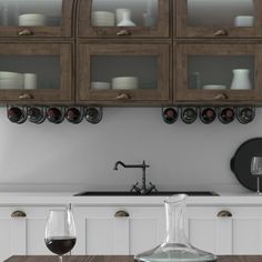 a kitchen counter with wine glasses on it