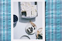 an overhead view of desserts and plates on a blue plaid tablecloth with the words, what's in there?