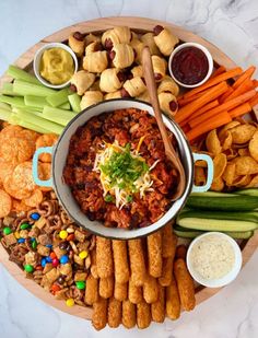 a platter filled with different types of snacks and dips on top of it