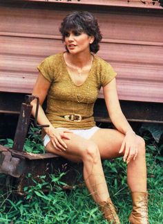 a woman sitting on top of a wooden bench