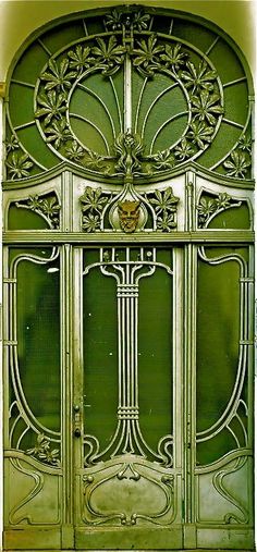 an ornate green door with glass panels