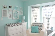 a baby's room with blue walls and pictures on the wall