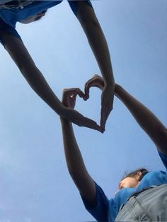 two people holding hands in the shape of a heart