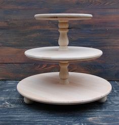 three tiered wooden cake stand on top of a wood table with the words handmade at amazon below it