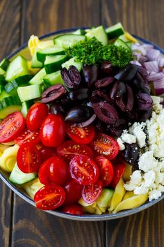 a salad with tomatoes, cucumbers, olives and feta cheese in a bowl