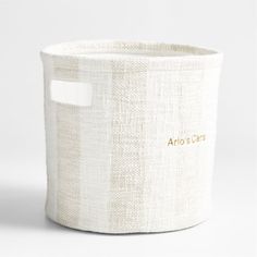 a white basket with gold lettering on the front and bottom, sitting against a white background