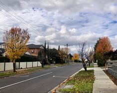 an empty street with houses and trees in the background