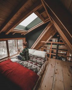 a person sitting on top of a bed in a loft