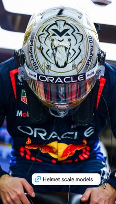 a man sitting on top of a motorcycle wearing a helmet with the word oracle printed on it