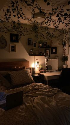 a bedroom with a bed, desk and pictures on the wall above it at night