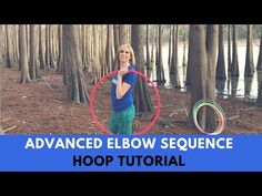 a woman is standing in the woods with a hula hoop and holding her hands up