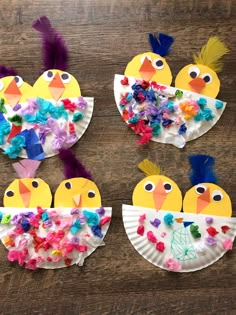 four paper plates decorated with birds and flowers on a wooden table, one is made out of construction paper