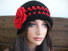 a mannequin head wearing a black and red knitted hat with flowers on it