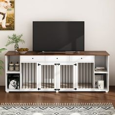 a dog is sitting on the floor in front of a flat screen tv and entertainment center