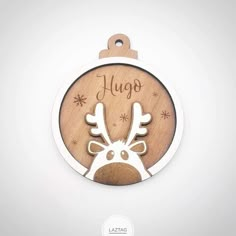 a wooden christmas ornament with a reindeer face and name on the front side