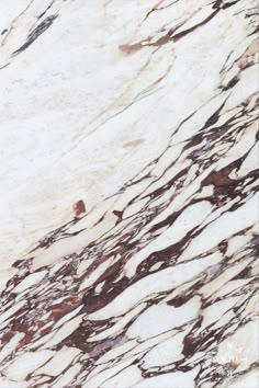 the marble is white and brown with some black streaks on it's surface,