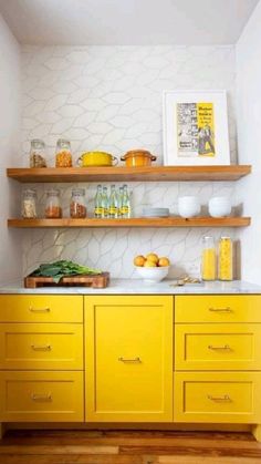 a kitchen with yellow cabinets and shelves filled with food