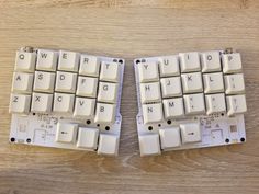 two white keyboards sitting on top of a wooden table