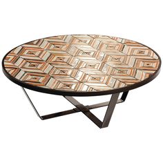 a round table with an intricate design on it's top and metal legs, against a white background