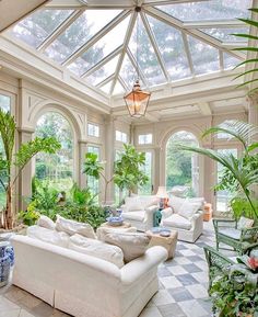 a living room filled with lots of furniture and plants on top of it's walls