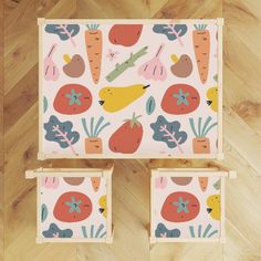 two wooden boxes with vegetables on them sitting on a wood floor next to each other