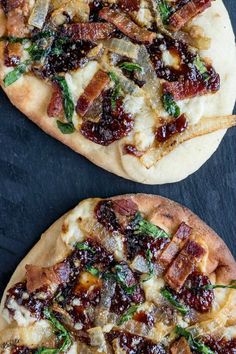 two pizzas sitting on top of a table covered in cheese and bacon toppings