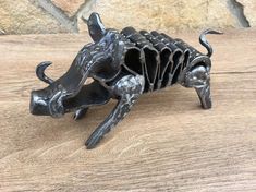 a metal sculpture of a boar on a wooden table