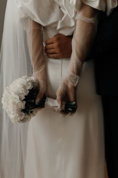 the bride and groom are holding their wedding bouquets in their hands as they stand close to each other