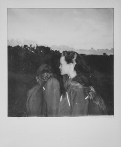 two women standing next to each other on a field