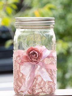 a mason jar filled with lace and a pink flower