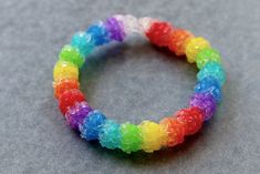 a rainbow bracelet is shown on a gray surface