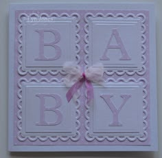 a pink and white greeting card with a bow on the front that says, baby