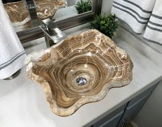 a bathroom sink sitting under a mirror next to a towel rack