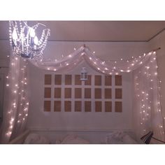 a room with lights and curtains on the wall above it is a chandelier