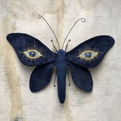 a blue butterfly with gold eyes on it's wings