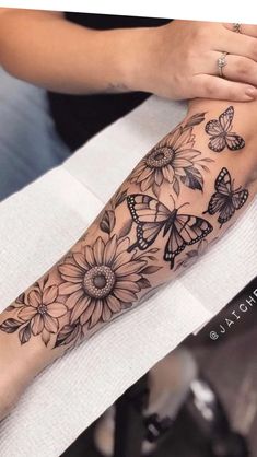 a woman is getting her tattoo done with butterflies and sunflowers on her arm