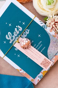 a close up of an open book on a table with flowers and other items around it