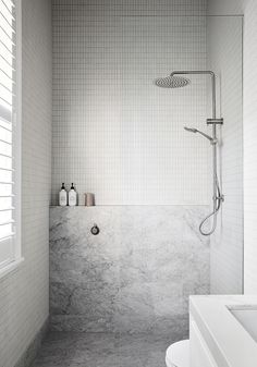 This all-white interior heritage cottage renovation is a dream! Empire Interiors creates depth and interest in this all-white home using stone, brick, moulding and playing with neutral colours. This modern minimalist bathroom is a small a glimpse into this beautiful heritage renovation. Bathroom styling: white subway tiles, grey hald wall design, nickel tapware, simple shampoo and conditioner bottles, window shutters. Check out the full tour of this timeless Edwardian house by clicking the pin! Tropical Inspiration, Makeover Kamar Mandi, Tiled Bathroom, Mini Bad, Shower Toilet, Albert Park, Cottage Renovation, Interior Minimalista