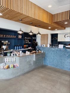 the inside of a coffee shop with blue walls and wood ceilinging on the ceiling