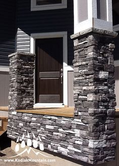 the front entrance to a house with stone pillars