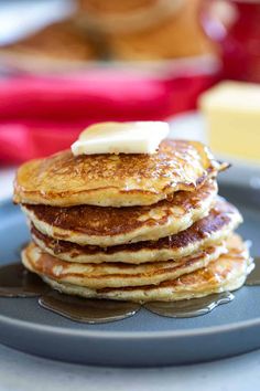 stack of pancakes with butter and syrup on blue plate, ready to be eaten for breakfast