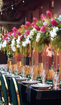 the tables are set with wine glasses and flowers in vases on each one side