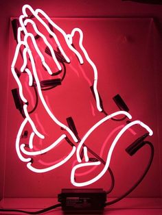 a neon sign that is lit up in the dark with hands and feet on it