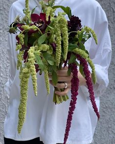 a person holding a bunch of flowers in their hands