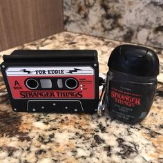 a black and red tape recorder sitting on top of a counter next to a trash can