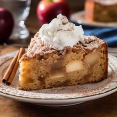 a slice of apple pie on a plate with cinnamon sticks and an apple in the background