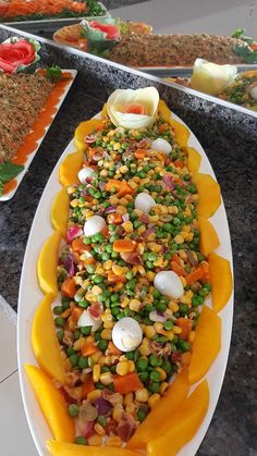 a large platter filled with lots of food on top of a table next to other plates